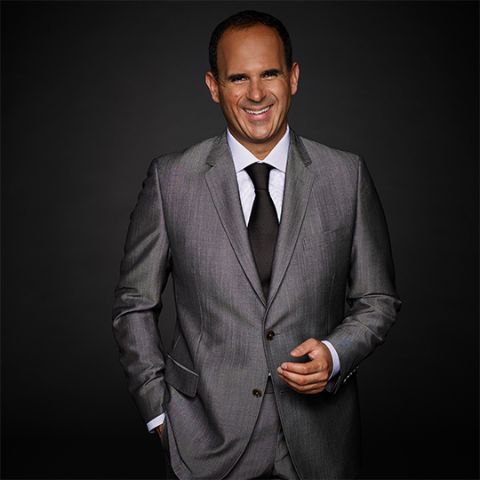 Marcus Lemonis in a grey suit poses a picture.